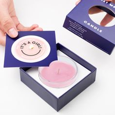 a person is holding a candle in a box