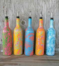 four colorful bottles are lined up on a table