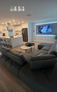 a living room filled with furniture and a flat screen tv mounted to the side of a wall