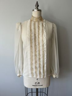 "A lovely soft vintage blouse in perfect cubdutiin except for the bottom button is missing. Would look great paired with fitted pants or a pencil skirt! Size: XS/S Tag - none Era - 80s Material - blend, plastic buttons, lace Bust - 32 to 34\" Waist - 26 to 28\" Arm length - Length - Washing - lightly steam clean or delicate cold wash in laundry bag, hang to dry" Fitted Pants, Gold Blouse, Cream Blouse, Gold Lace, Puffy Sleeves, Dressy Tops, Vintage Coat, Mode Vintage, Blouse Vintage