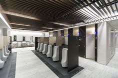 a public restroom with urinals and sinks on the walls, along with other stalls