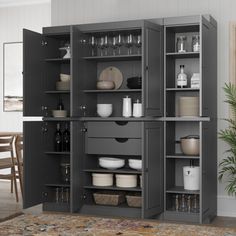 an open cabinet with dishes and glasses on it in a living room next to a dining room table