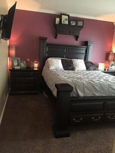 a bedroom with purple walls and black furniture