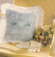 a white pillow sitting on top of a wooden chair next to a bouquet of flowers