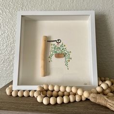 a wooden bead frame with a painting on it and beads around it in front of a white wall