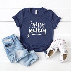 Looking for a cute versatile top to wear? Make sure to grab one of our Graphic tees! This soft and comfortable graphic tee is the perfect top for any outfit. It can be paired with biker shorts, jeans, or even a simple skirt/dress! This tee is true-to-size, so be sure to order your regular t-shirt size! If you are looking for a more oversized look, make sure to size up! Trendy Navy Top With Letter Print, Navy Graphic Tee With Letter Print, Blue Graphic Tee With Lettering, Navy Graphic Tee With Text Print, Find Joy In The Journey, Tiny Tank, Joy In The Journey, Trending Graphic Tees, Simple Skirt