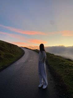 a woman standing on the side of a road