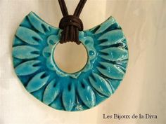 a blue ceramic pendant hanging from a leather cord on a white background with the words le biooxx de la deva written below it