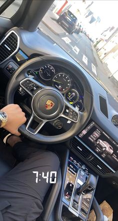 a man sitting in the driver's seat of a car with his hands on the steering wheel