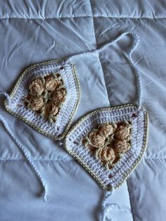 two crocheted doily with flowers on them laying on a white bed sheet