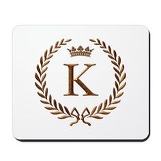 a white mouse pad with the letter k in a crown and laurel design on it