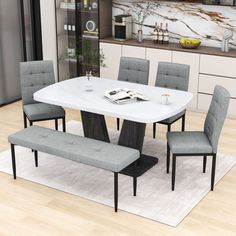 a dining room table with four chairs and a bench