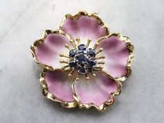 "Outstanding. There's no other word to describe this stunning brooch! The enamel is delicately colored, softly textured and perfectly detailed. The tiny veins and subtle shading of the petals are completely life-like! We've centered this vintage piece with a cluster of navy blue sapphires. Exquisite workmanship is the hallmark of this lovely flower brooch! Love this piece, but want to make it more versatile? We here at Market Square Jewelers, along with our master metalsmiths can convert this fa Sapphire Brooch, Plain Gold Ring, Magnolia Blossom, Market Square, Pink Enamel, Enamel Flower, Flower Jewelry, Flower Pins, Colourful Necklace