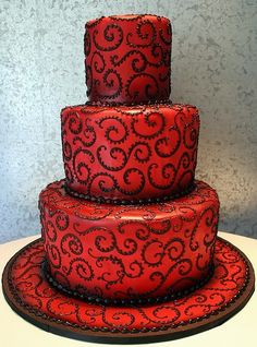 a three tiered red cake sitting on top of a table