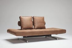 a couch with two pillows sitting on it's back legs and one arm extended