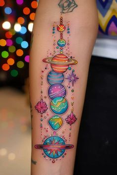 a colorful tattoo on the leg of a woman with planets and stars around her arm