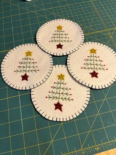 four christmas tree coasters on a cutting board