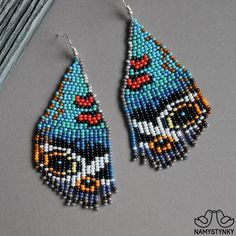 two pairs of beaded earrings on top of a table