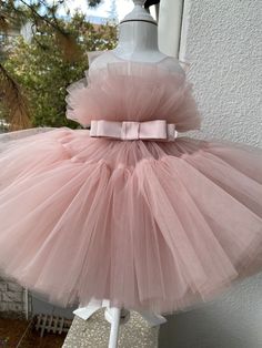 a pink tutule dress on display in front of a window