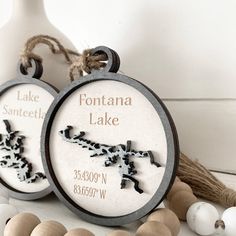 two personalized porcelain ornaments are sitting on a table next to beads and other decorations