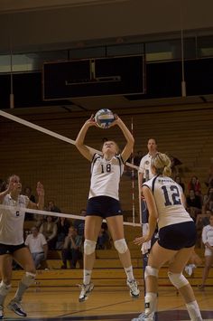 the volleyball players are trying to block the ball