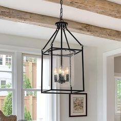 a chandelier hanging from the ceiling in a room with white walls and windows