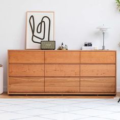 a large wooden dresser sitting in a living room next to a painting on the wall