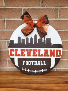 the cleveland football sign is mounted on a brick wall, with a bow in front of it