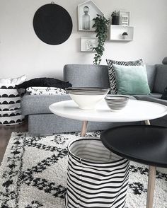 a living room with black and white decor on the walls, furniture and rugs