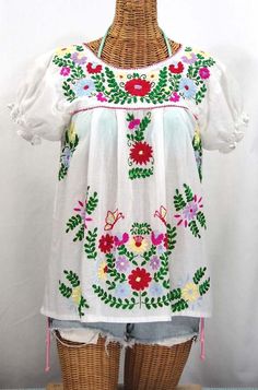 "* Ornate hand embroidery and traditional puff sleeves, available here in WHITE with BRIGHT MULTI-COLOR embroidery. * Light, gauzy and semi-sheer 100% cotton throughout; wear it billowy and flowing in the traditional bohemian style. * Dyed, distressed and embroidered entirely by hand for an authentic, retro-vintage and hippie casual vibe. * Our ornate butterfly floral embroidery patterns are a faithful tribute to the original Mexican style hippie blouses of the 1970's. * Caringly embroidered by Traditional White Embroidered Top, Traditional White Top With Intricate Embroidery, White Cotton Peasant Top With Embroidered Sleeves, White Puff Sleeve Blouse With Floral Embroidery, Folk Style Fitted White Embroidered Top, White Puff Sleeve Tops With Embroidered Sleeves, Fitted White Folk Peasant Top, Traditional Embroidered Multicolor Peasant Top, Fitted Embroidered Traditional Peasant Top