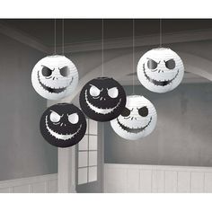 three black and white paper lanterns with faces hanging from the ceiling