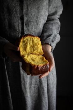 a person holding a piece of bread in their hands