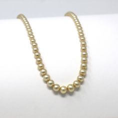 "Pretty vintage circa 1940s era 14k yellow gold simulated pearl necklace! This lovely necklace is comprised of graduated simulated pearl beads in off white, with a 14k yellow gold fish hook clasp. A classic 1940s era fashion accessory, featuring June's birthstone! *Sale - price reduced from $195 USD to $175 USD.  ERA - Circa 1940s - Retro METAL / MATERIAL - 14k yellow gold, simulated pearls MARKINGS / HISTORY - Clasp is marked \"14K A\" CONDITION - Good vintage condition. Yellow gold metal has b Antique Pearl Chain Necklace For Formal Occasions, Antique Formal Pearl Chain Necklace, Vintage Gold Round Pearl Necklace, Classic Gold Single Strand Pearl Necklace, Classic Gold Pearl Necklace, Gold Pearl Necklace With Round Beads For Formal Occasions, Vintage Gold Single Strand Jewelry, Classic Gold Round Pearl Necklace, Classic Gold Pearl Necklaces