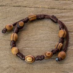 Lesbia Back exalts the beauty found in nature with this handcrafted bracelet. Tropical parota wood beads bring an earthy allure to her design. The Guatemalan artisan knots them by hand and the length can be adjusted by sliding the knot along the dark brown cords. Nature-inspired Adjustable Beaded Bracelet With Round Beads, Natural Wooden Beads Spiritual Bracelet, Adjustable Beaded Nature-inspired Bracelet, Artisan Wooden Beads Bracelets For Meditation, Adjustable Natural Jewelry With Wooden Beads, Nature-inspired Hand-strung Beaded Bracelets, Handmade Wooden Beaded Bracelets For Meditation, Adjustable Natural Wooden Bead Jewelry, Adjustable Natural Wooden Beaded Jewelry