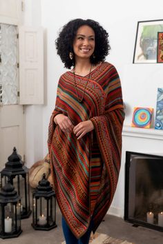 Alfredo Falcon of Peru designs this striped acrylic poncho with bold colors and a mixture of geometric motifs. A touch of baby alpaca gives adds to the poncho's warmth and feel. Lightweight the poncho makes a wonderful layering piece. Alfredo Falcon learned the craft of weaving from his parents who learned from their parents before them. He says âWe have been a family devoted to the world of textiles for generations. I use modern colors but I remain true to Incan and colonial motifs.â Wool Blanket Poncho Capes, Luxury Merino Wool Poncho For Fall, Poncho Made Out Of Blanket, Boho Long Sweaters, Cheap Fall Poncho, Maxi Skirt With Poncho, Affordable Cozy Poncho, Navajo Long Sweater, Cheap Multicolor Bohemian Poncho