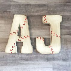 the letters are made out of wood and have red thread on them, along with an arrow