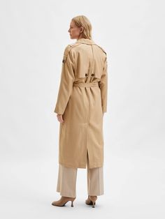 This beige trench coat is designed with a double-breasted closure and side pockets for a stylish and practical look. It has raglan sleeves and a reverse collar for a modern and sophisticated look. It is made from a high quality piqué fabric which makes it durable and comfortable to wear.
 Normal/large size.
 This coat is fully lined with 100% recycled polyester fabric , making it even more sustainable and environmentally friendly. Additionally, 52% of the composition of this coat is TENCEL™ Lyocell , a high-quality cellulose fiber made from wood pulp from sustainably managed forests.
 This makes this coat a sustainable choice for those looking for high-quality, environmentally friendly products. You can wear it on any occasion and feel comfortable and elegant at the same time. Longline Trench Coat, Beige Trench Coat, Double Breasted Trench Coat, Coat For Women, Trench Coats Women, Overall Dress, Trench Coats, Fashion Labels, Tie Belt