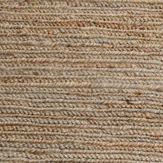 the texture of an area rug with brown and tan colors, including braided ends