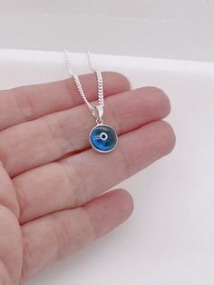 "925 Sterling Silver Evil Eye Necklace. It helps ward off all evil eyes from you and creates a protective shield against you.  The Evil Eye necklace is favorite among celebrities. It's specifically a favorite of Vanessa Hudgens, Cameron Diaz, Sharon Stone, Richard Gere.  . Looking to add customized Charms ? http://etsy.me/ZQ2KkF . More Meaningful Jewelry:  http://www.TitinaJewelry.etsy.com  DETAILS: . Solid 925 Sterling silver cubic zirconia evil eye pendant . . Solid 925 Sterling Silver chain, Authenticity verified, Nickel and lead free.  ~ GENUINE 925 STERLING SILVER JEWELRY 0r FAKE SILVER? -The easiest test to do is to use a magnet. Metals, such as sterling silver, gold and platinum, are non-ferrous materials. If it is attracted to it, then it is not sterling silver. ( except for the cl Sterling Silver Evil Eye Charm Necklace, Blue Sterling Silver Charm Necklaces, Sterling Silver Gemstone Charm Necklace, Blue Sterling Silver Charm Necklace, Silver Evil Eye Round Pendant Necklace, Silver Necklace With Evil Eye Round Pendant, Silver Evil Eye Jewelry Gift, Silver Charm Necklace With Evil Eye Pendant, Sterling Silver Charm Necklace With Evil Eye Round Pendant