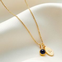 "Sapphire birthstone pendant necklace by Claudette Worters.  This real faceted blue sapphire birthstone pendant necklace is cast in sterling silver with a little row of genuine sparkling diamonds, plated in 18 carat gold. Sapphire is the birthstone for the month of September. Customise your diamond birthstone necklace by adding small gold oval charms. Add a letter or a number to be hand stamped onto them. You could add your child's initials to this semi precious birthstone necklace or your own. You could add numbers to commemorate a milestone birthday.  Or you could add a number to represent an anniversary.   These birthstone necklaces would also make a fabulous gifts for all of your bridesmaids or a really thoughtful Mother's Day gift. Only one letter or a maximum of two numbers can be st Sapphire Birthstone Jewelry As Gift For Her, Sapphire Birthstone Jewelry For Her, Personalized Blue Jewelry For May Birthstone, Personalized Blue May Birthstone Jewelry, Silver Birthstone Necklace With Oval Pendant, Elegant Birthstone Necklace With Charms For Birthday, Silver Oval Pendant Birthstone Necklace, Sapphire Birthstone Jewelry For Gifts, Sapphire Birthstone Jewelry As Gift