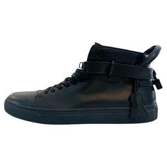 Buscemi Leather High-Top Sneakers With Padlock Detail Black lace-up sneakers designed with round toe and strap around the ankle. Detailed with black 'Buscemi' engraved padlock to rear and leather clochette to the side and featuring logo embossment to the tongue. Size – 46 Condition – Very Good Composition – Leather Comes with – Shoes Only Leather High-top Sneakers With Round Toe And Laces, Leather High-top Sneakers With Laces, Leather High-top Sneakers For Streetwear With Flat Heel, Leather High-top Lace-up Sneakers, Ankle-high Leather Sneakers With Laces, Black Leather High-top Sneakers With Laces, Lace-up High-top Sneakers With Removable Insole For Streetwear, Streetwear High-top Lace-up Sneakers With Removable Insole, High-top Sneakers With Removable Insole