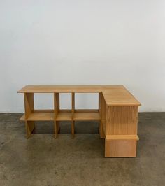 a wooden desk and shelf in an empty room