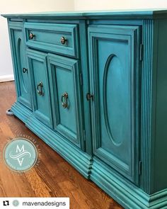 an old dresser painted in teal green with brass pulls and knobs on the doors