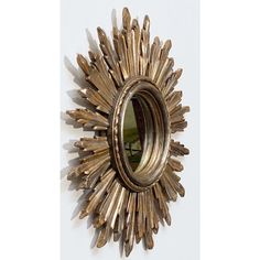 a sunburst shaped mirror hanging on the wall