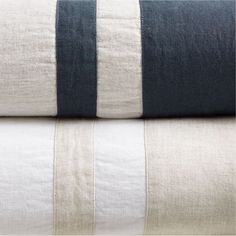 two black and white striped linens stacked on top of each other in different colors