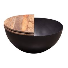 a black bowl with a wooden lid on it's side and a wood plate in the middle