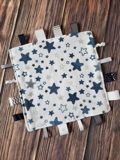 a blue and white blanket with stars on it sitting on top of a wooden floor