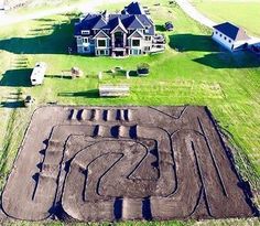 an aerial view of a home with a track in the yard