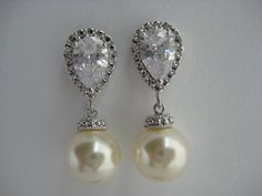 Classic cubic zirconia and pearl bridal earrings in rhodium plated brass setting. Earrings feature clear cubic zirconia teardrop ear post and a 10mm Swarovski cream pearl dangle drop. Total length of the earrings is 2.7 cms.For matching necklace click:https://www.etsy.com/listing/252977878/cream-pearl-and-crystal-bridal-necklace?ref=shop_home_active_10For matching bracelet click:https://www.etsy.com/listing/253699301/classic-bridal-cream-pearl-bracelet?ref=shop_home_active_5 To browse my collect Silver Pear-shaped Bridal Earrings For Anniversary, Silver Pear-shaped Cubic Zirconia Bridal Earrings, White Gold Cubic Zirconia Pearl Earrings For Wedding, Classic Silver Pearl Earrings For Wedding, Silver Classic Pearl Earrings For Wedding, Classic Pearl Earrings With Cubic Zirconia For Wedding, Classic Cubic Zirconia Pearl Earrings For Wedding, Pearl Bridesmaid Jewelry, Engagement Look