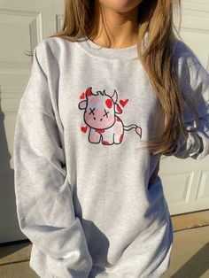 Look sweet and comfy in our Valentine Cow Crewneck Sweatshirt. This sweatshirt features long sleeves, a crew neckline, and beautiful front embroidery. The Unisex Sizing makes the sweatshirt run slightly larger than your average sweatshirt for women. Most men find their normal size to be more snug. If you want a slightly looser fit, size up one size. Please check out our size chart for measurements to ensure an accurate fit. PLEASE BE SURE TO INPUT YOUR CORRECT SIZE/COLOR + SHIPPING ADDRESS. We w Casual Embroidered Long Sleeve Tops, Gray Long Sleeve Fleece Top, Cotton Long Sleeve Sweatshirt With Graphic Print, Trendy Gray Long Sleeve Sweatshirt, Trendy Long Sleeve Gray Sweatshirt, Casual Long Sleeve Spring Sweatshirt, Embroidered Long Sleeve Trendy Hoodie, Trendy Long Sleeve Embroidered Hoodie, Gray Fleece Long Sleeve Sweatshirt